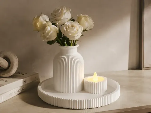 Composição decorativa marfim com vaso canelado, bandeja redonda e pequeno suporte com luz decorativa