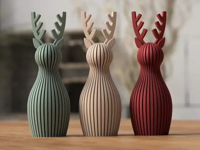 Renas decorativas caneladas nas cores verde, bege e vermelho sobre uma mesa de madeira